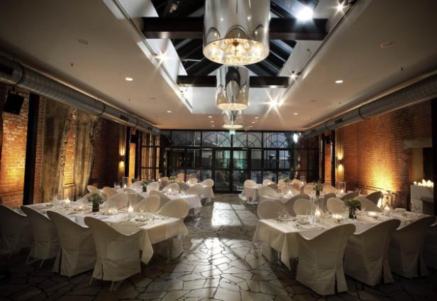 Ein festlich dekorierter Raum mit Tischen und Stühlen für eine Veranstaltung.