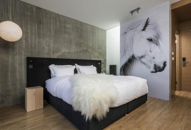 Ein Schlafzimmer mit einem großen Pferdeporträt an der Wand.