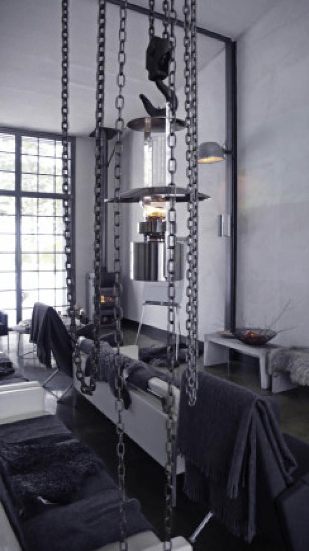 Eine ungewöhnliche Lampe hängt an Ketten über einer Sitzecke.