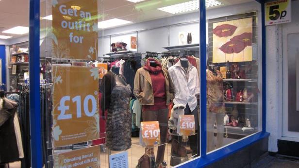Ein Schaufenster mit Kleidung und Accessoires, beworben mit dem Slogan „Get an outfit for £10“.