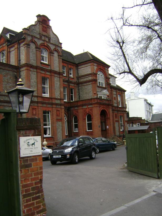 Das Palmers Lodge Swiss Cottage, ein Backpacker-Hostel in London, mit geparkten Autos davor.