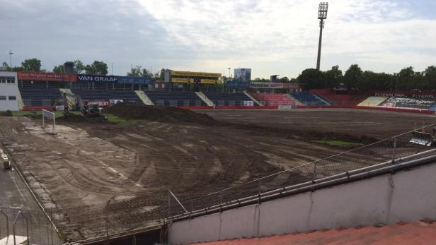 Ein Fußballstadion wird mit schwerem Gerät umgegraben.