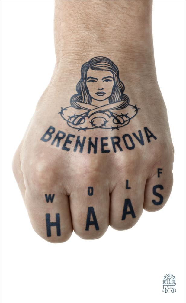 Die tätowierte Faust einer Person zeigt das Gesicht einer Frau, den Namen Brennerova und Wolf Haas.