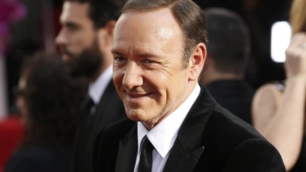 Kevin Spacey lächelt in einem schwarzen Anzug.