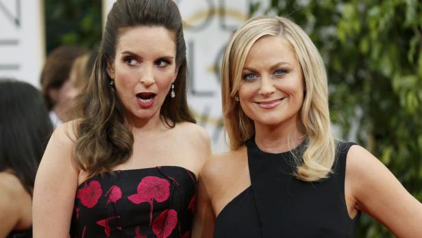 Tina Fey und Amy Poehler posieren auf dem roten Teppich.