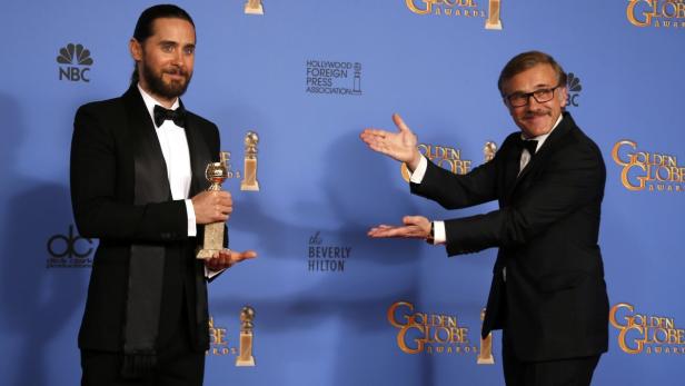 Jared Leto hält einen Golden Globe, während Christoph Waltz daneben steht und gestikuliert.