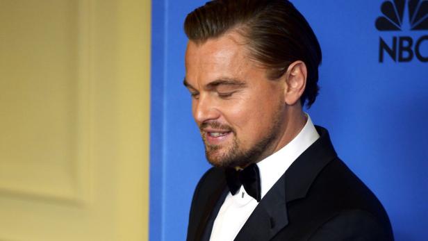 Leonardo DiCaprio im schwarzen Smoking vor einem blauen Hintergrund mit dem NBC-Logo.
