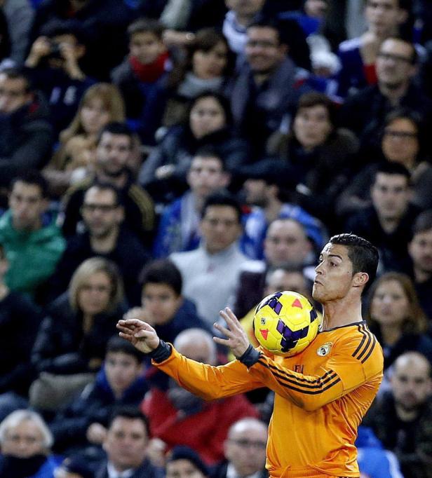 Cristiano Ronaldo jongliert mit einem Ball vor einer Zuschauermenge.