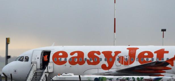 Ein EasyJet-Flugzeug steht auf dem Rollfeld, eine Person steigt die Treppe zum Flugzeug hinauf.