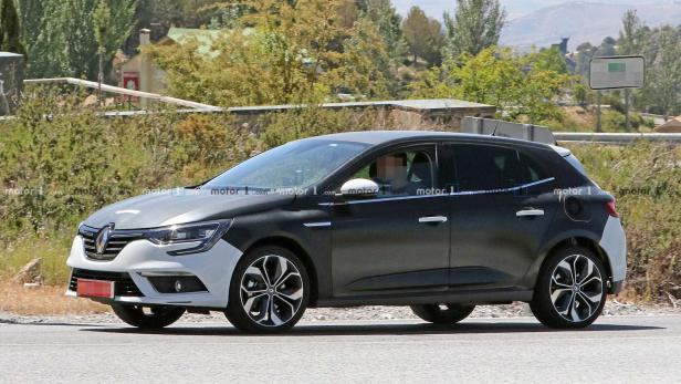 Ein teilweise getarnter Renault Mégane fährt auf einer Straße.