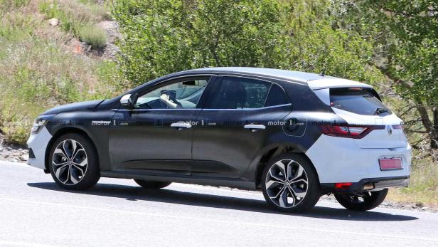 Ein getarntes Renault Mégane-Fahrzeug auf einer Straße.