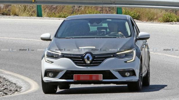Ein weißer Renault Mégane fährt auf einer asphaltierten Straße.