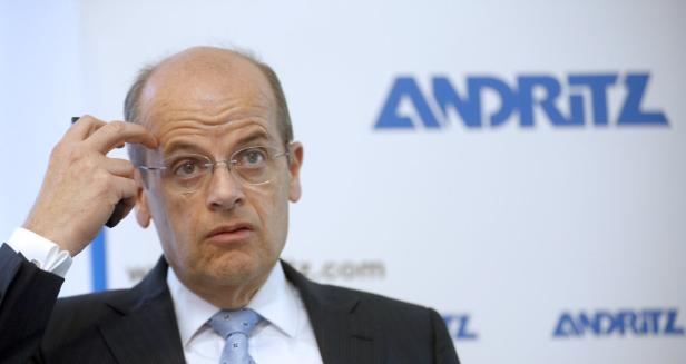 Ein Mann mit Brille gestikuliert vor einem Andritz-Logo.