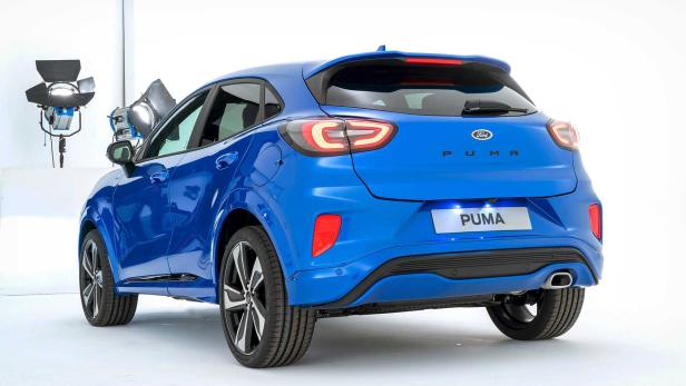 Die Rückansicht eines blauen Ford Puma vor einem weißen Hintergrund.