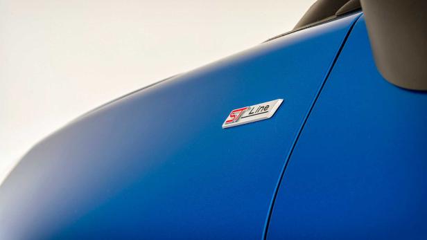 Das „ST-Line“-Emblem auf einem blauen Auto.