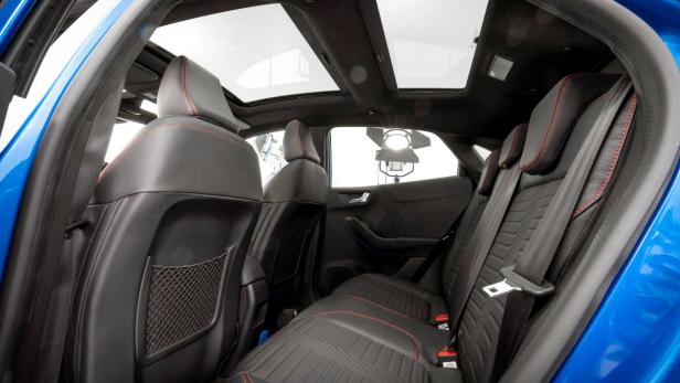 Der Innenraum eines Autos mit schwarzen Ledersitzen und einem Panoramadach.