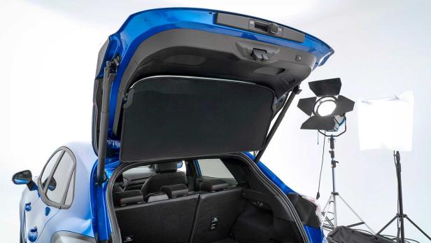 Der offene Kofferraum eines blauen Autos in einem Fotostudio.