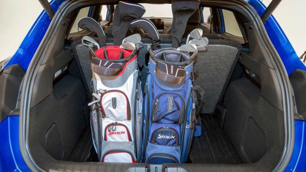 Zwei Srixon-Golfbags stehen im Kofferraum eines blauen Autos.