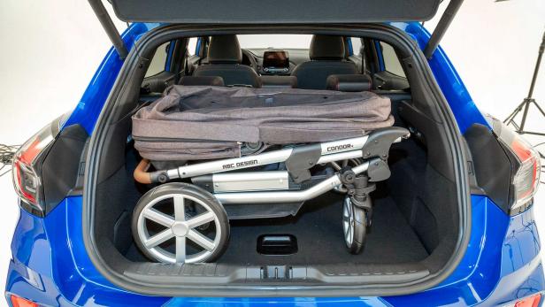Ein zusammengeklappter Kinderwagen der Marke ABC Design im Kofferraum eines blauen Autos.