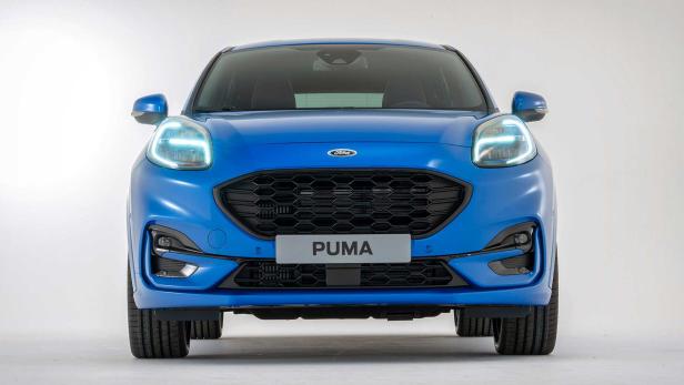 Die Frontansicht eines blauen Ford Puma mit eingeschalteten Scheinwerfern.