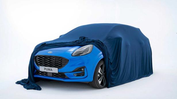 Ein blauer Ford Puma, teilweise mit einem blauen Tuch bedeckt.