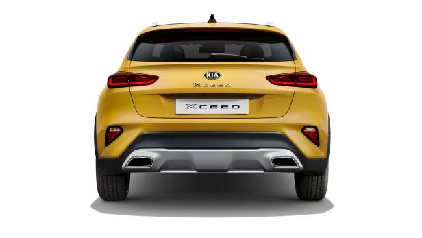 Die Rückansicht eines gelben Kia XCeed vor einem weißen Hintergrund.