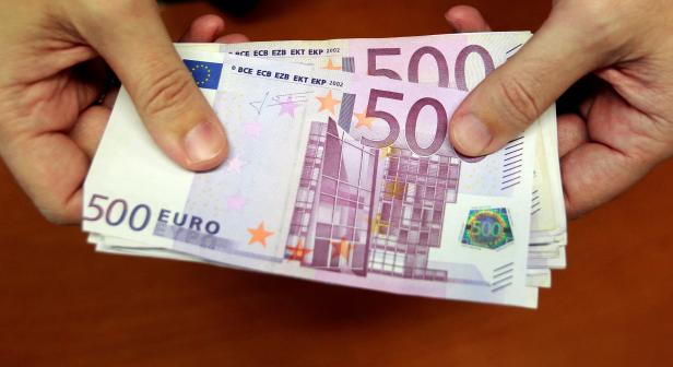 FILE PHOTO: A bank employee holds a pile of 500 euro bank notes in Madrid