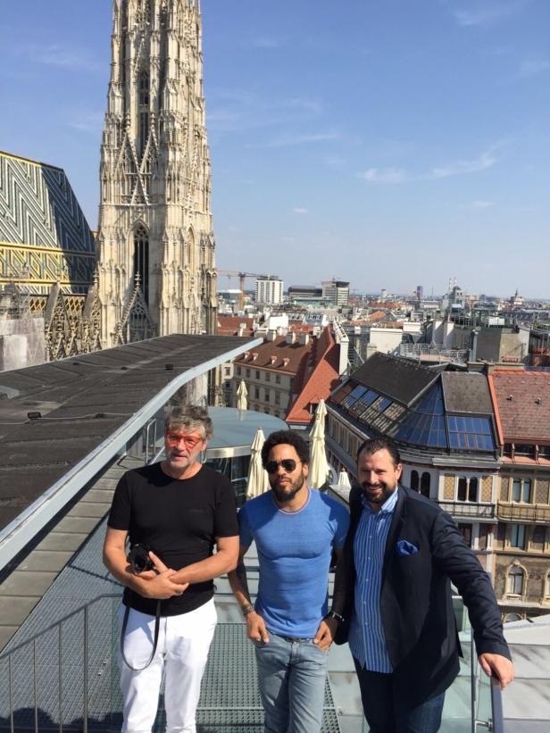 Drei Männer posieren auf einem Dach mit dem Stephansdom im Hintergrund.