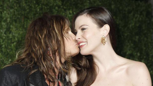 Steven Tyler küsst seine Tochter Liv Tyler auf die Wange.