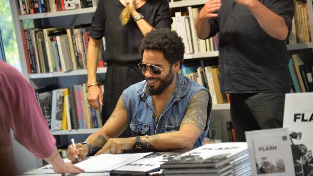 Lenny Kravitz signiert Bücher in einem Buchladen.