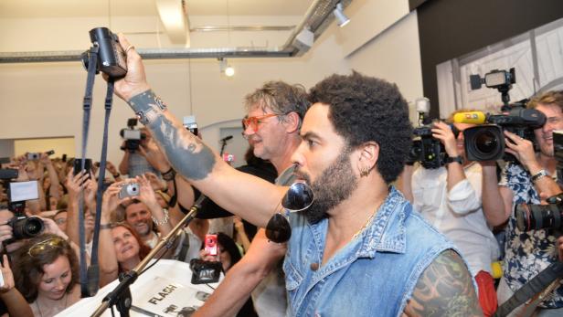 Lenny Kravitz bei einer Veranstaltung, umringt von Fotografen und Fans.