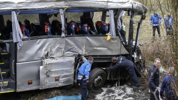 Ein schwer beschädigter Reisebus nach einem Unfall mit Polizisten vor Ort.