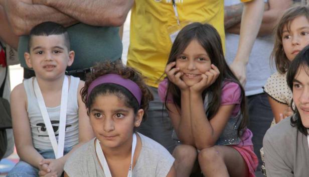 Eine Gruppe von Kindern sitzt zusammen und schaut in die Kamera.