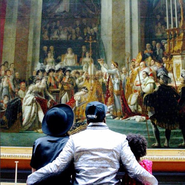 Drei Personen betrachten das Gemälde „Die Krönung Napoleons“ im Louvre.