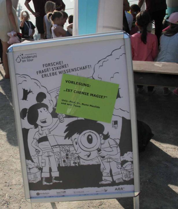 Ein Plakat der Kinderuni on Tour kündigt eine Vorlesung mit dem Titel „Ist Chemie Magie?“ an.