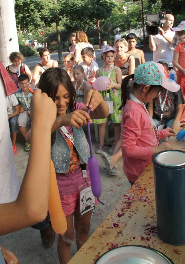 Kinder formen auf einer Veranstaltung Luftballons zu Figuren.