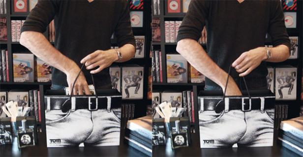 Ein Mann greift in eine Einkaufstasche mit einem Aufdruck einer Jeanshose.