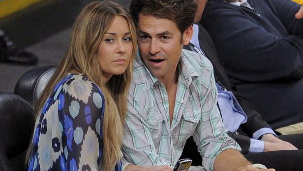 Lauren Conrad und ihr Begleiter sitzen bei einer Sportveranstaltung.