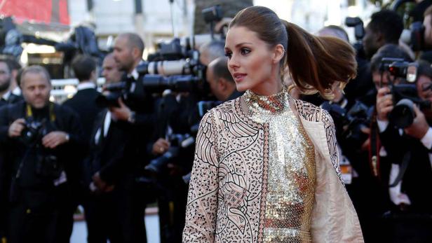 Olivia Palermo posiert auf dem roten Teppich vor einer Gruppe von Fotografen.