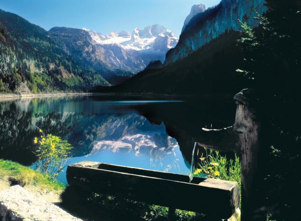 Ein Bergsee spiegelt die schneebedeckten Gipfel der Alpen wider.