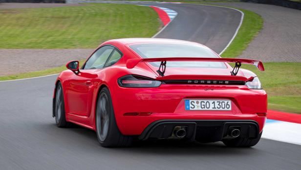 Ein roter Porsche GT4 fährt auf einer Rennstrecke.
