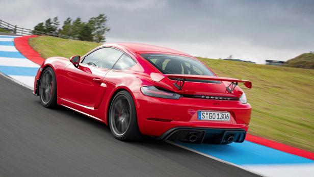 Ein roter Porsche GT4 fährt auf einer Rennstrecke.