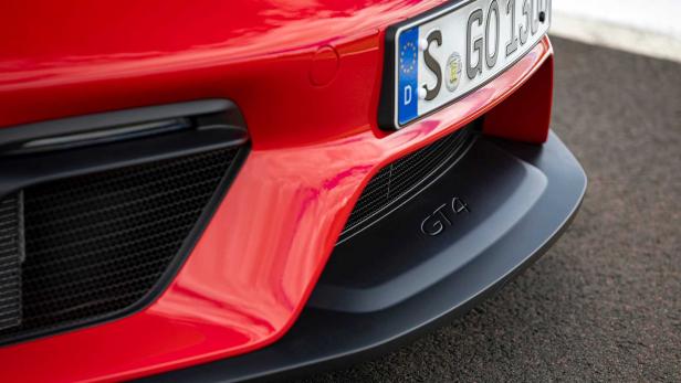 Detailansicht der Frontpartie eines roten Porsche GT4 mit Kennzeichen.