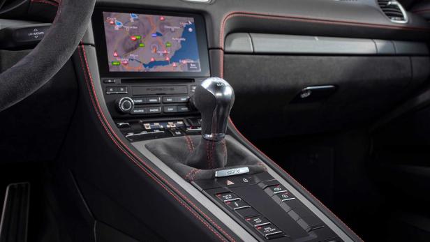 Innenraum eines Porsche GT4 mit Schaltknüppel und Navigationssystem.
