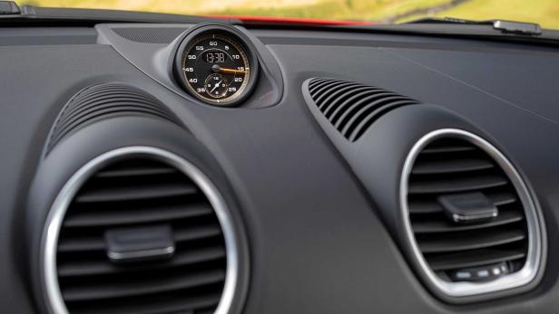 Das Armaturenbrett eines Autos mit einer Analoguhr, die 13:38 anzeigt.