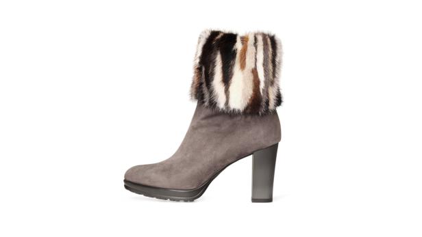 Ein grauer Wildlederstiefel mit hohem Absatz und einem Pelzbesatz.