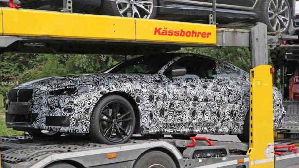 Ein mit einem Muster getarntes Auto wird auf einem Anhänger transportiert.