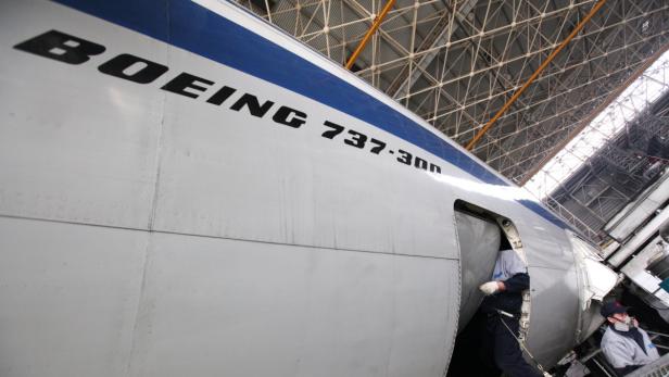 Ein Arbeiter betritt eine Boeing 737-300 in einem Hangar.
