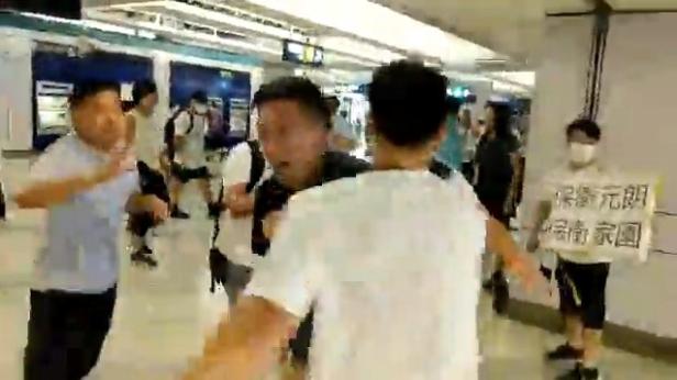 Social media video grab of men in white t-shirts and face masks attacking anti-extradition bill demonstrators and reporters at a train station in Hong Kong