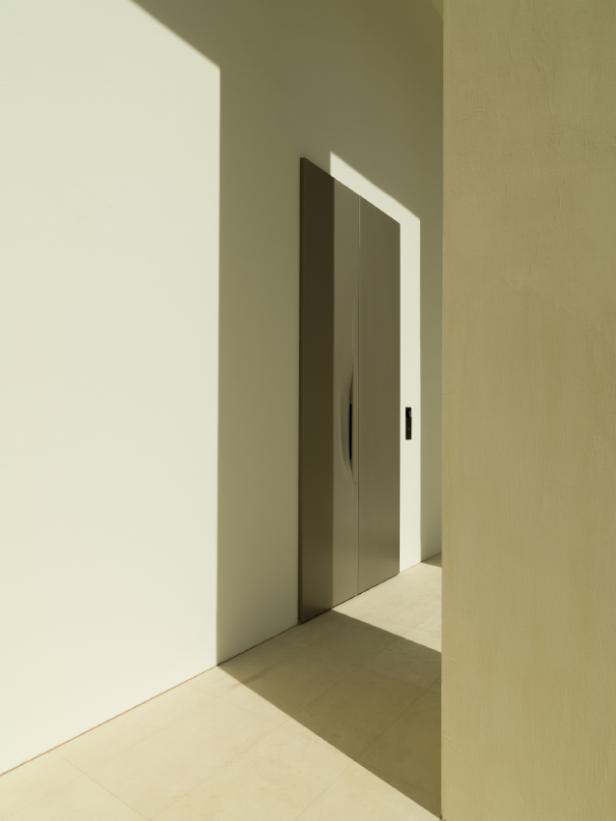 Eine graue Tür fügt sich nahtlos in eine helle Wand ein.